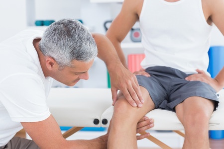 doctor examining knee